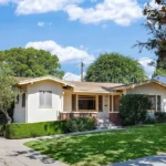 real estate house with white walls and red brick accents
