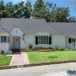 Real estate house with a dark roof, arched windows, and a double garage