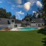 backyard with pool, house with dark roofs and white walls