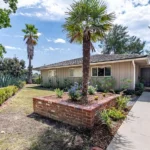 Single-story real estate house with beige siding and a tiled roof.